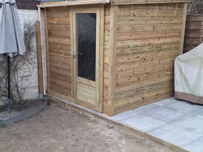 Abri en bois installé dans le jardin, vue du coin extérieur.