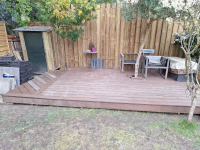 Terrasse bois installée dans un jardin avec mobilier, finition autour des bords.