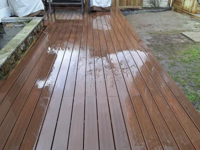 Terrasse bois installée dans un jardin avec mobilier, finition autour des bords.