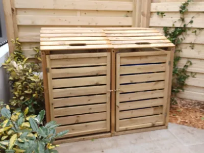 Cache poubelles en bois à double bac, intégré dans un aménagement extérieur soigné