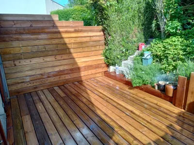 Terrasse en bois avec banquette intégrée et plantes décoratives en extérieur
