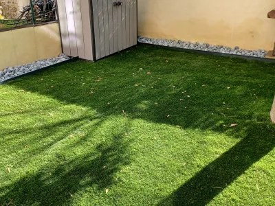 Pelouse naturelle installée dans un jardin clos avec abri de jardin