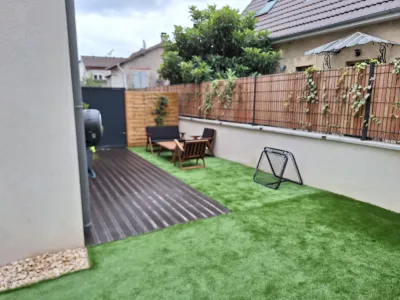 Aménagement de jardin avec terrasse bois, pelouse synthétique et espace repas