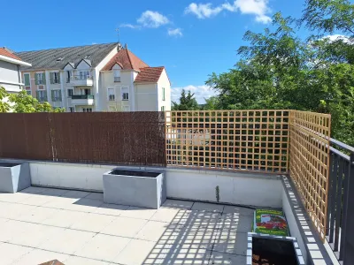 Aménagement de terrasse avec claustra en bois et brise-vue dans un espace urbain extérieur