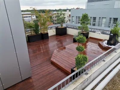 Terrasse en bois avec jardinières et vue sur les bâtiments voisins