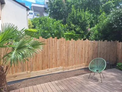 Palissade bois récente avec chaise et vue du jardin.