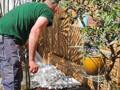Pose d’une clôture en bois avec finition gravier et aménagement paysager en cours
