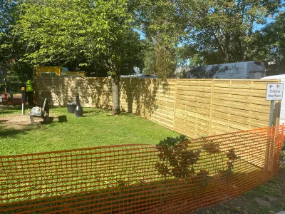Travaux d’aménagement extérieur avec haie, pelouse et clôture temporaire orange