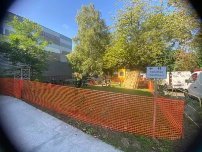 Chantier extérieur avec filet de sécurité orange et pelouse, installation en cours