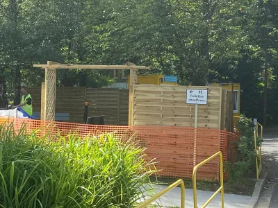 Installation de clôture en bois et zone sécurisée par filet orange sur chantier