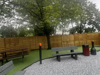 Allée avec bancs et poubelles, pelouse synthétique installée dans l’espace extérieur