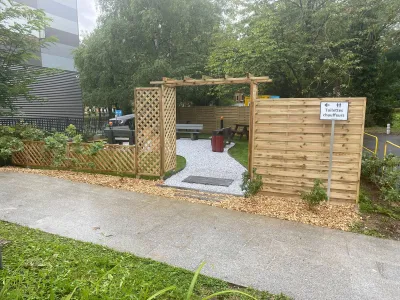 Entrée aménagée avec treillage et clôture en bois, allée en gravier et bancs