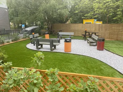 Espace extérieur finalisé avec allée sinueuse, pelouse synthétique et mobilier complet