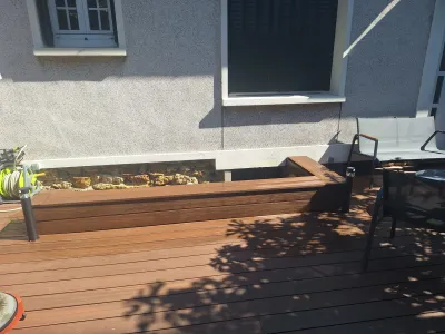 Terrasse bois avec banc intégré le long d’une façade de maison