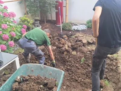 Travaux de terrassement manuel dans un jardin avant aménagement paysager