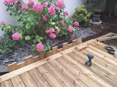 Début de pose d’une terrasse en bois avec structure et outils visibles