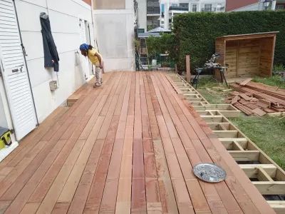 Pose de terrasse en bois en cours le long d’une maison individuelle