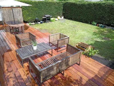 Terrasse en bois aménagée avec mobilier extérieur dans un jardin clos