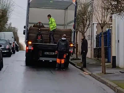 Équipe de paysagistes déchargeant du matériel depuis un camion pour travaux de jardin