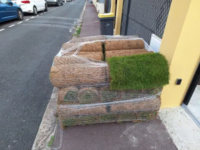 Rouleaux de gazon emballés et prêts à être installés sur un chantier extérieur