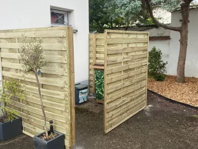 Palissade bois double entourant un coin de jardin.