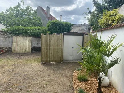 Clôture en bois installée dans un jardin avec abri extérieur et plantations