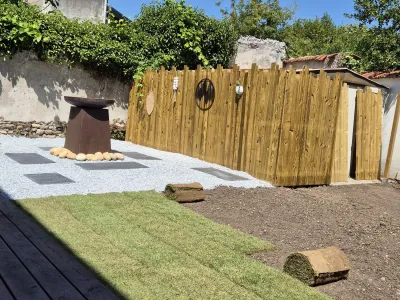 Aménagement de jardin avec gazon, gravier décoratif et clôture en bois