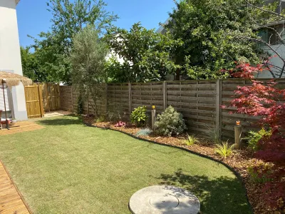 Jardin après installation de gazon, pelouse verte et bordures fleuries