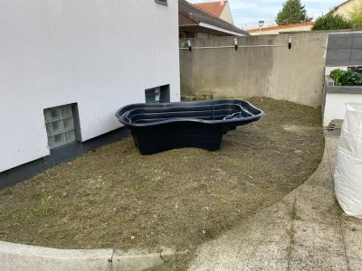 Jardin en préparation avec bassin vide posé sur terrain nu