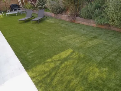 Pelouse artificielle parfaitement entretenue avec transats