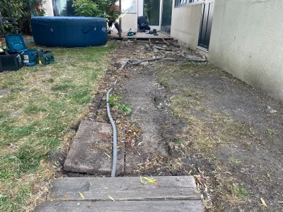 Jardin avant travaux avec sol dégagé et tranchée pour aménagement futur