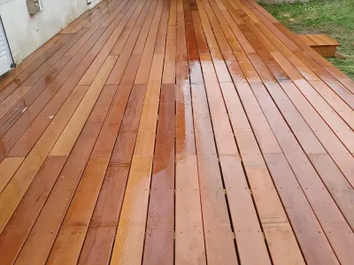 Terrasse en bois après traitement et nettoyage, lames humidifiées montrant la teinte naturelle du bois