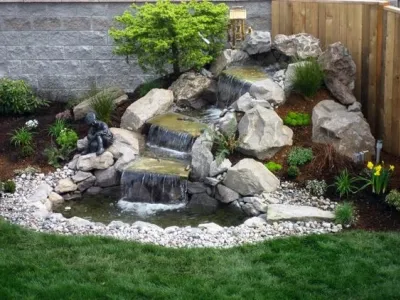 Petit bassin de jardin avec cascade, rochers et plantes décoratives