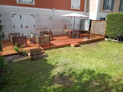 Terrasse en bois récemment installée avec salon de jardin dans un espace extérieur moderne et végétalisé