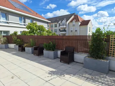 Terrasse aménagée avec jardinières et mobilier en plein soleil, vue sur le jardin