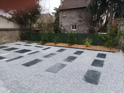 Cour moderne avec gravier blanc et dalles noires disposées en motifs